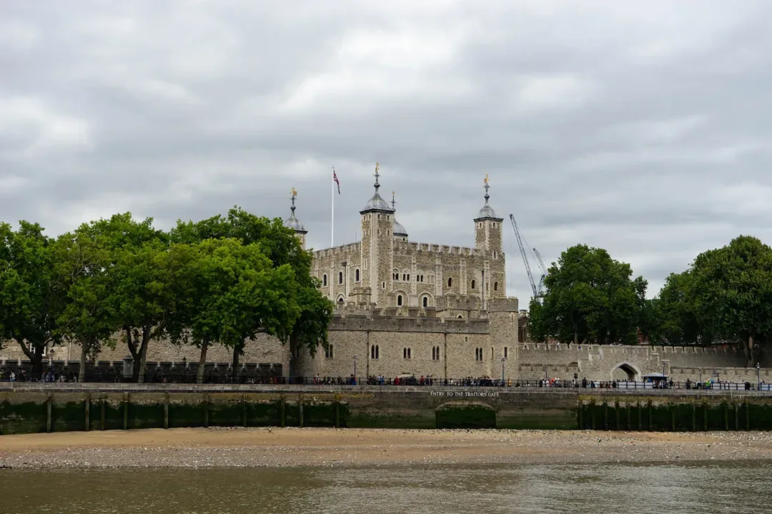 people walking near brown concrete castle under white skies
